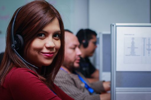 SkyCom Call Center agent with red jumper and headset smiling into camera