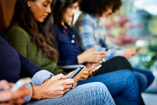 Young people with mobile phones in waiting room